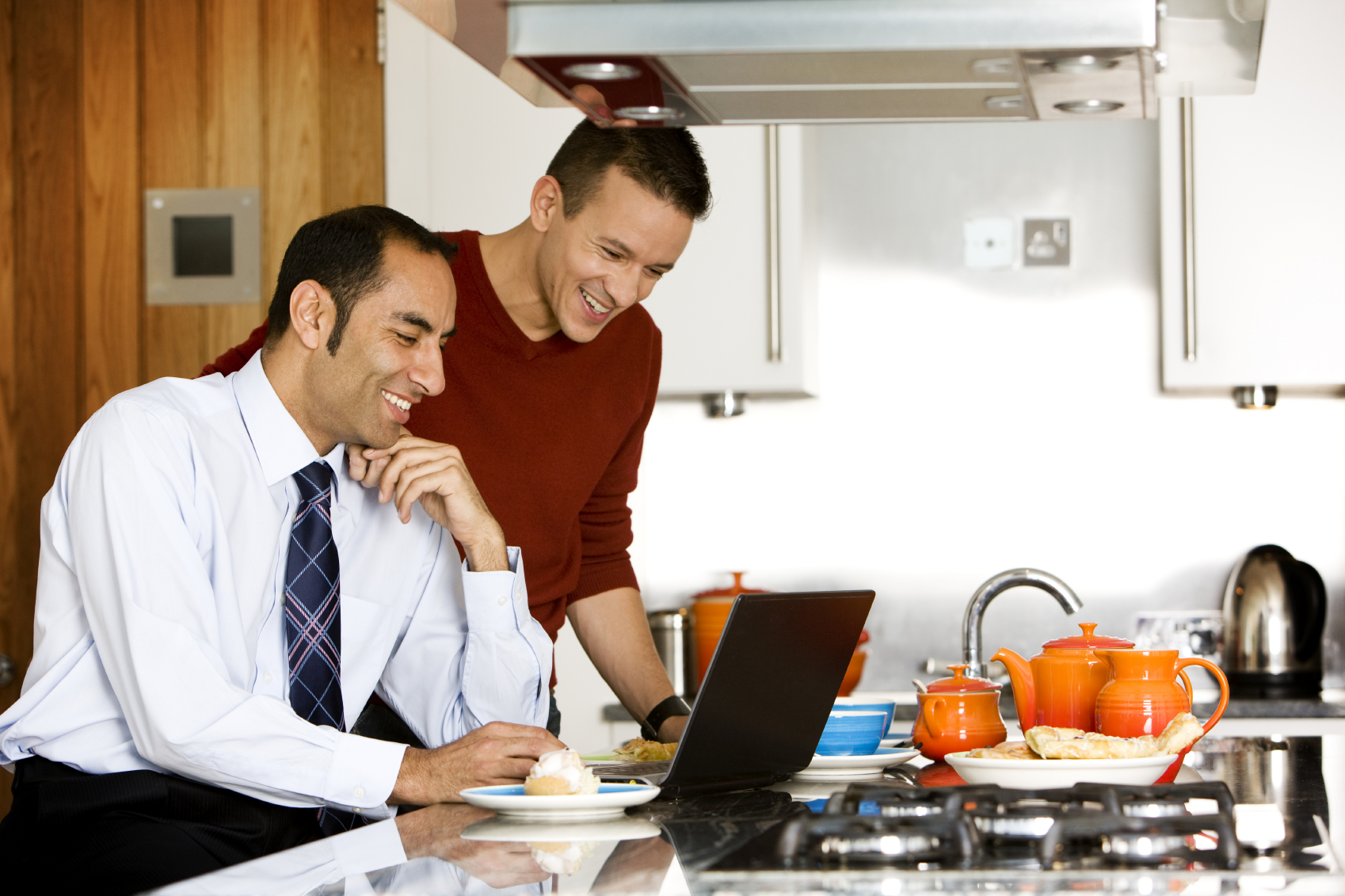 Dual Career Couple sitting in their kitchen, both looking at a laptop
