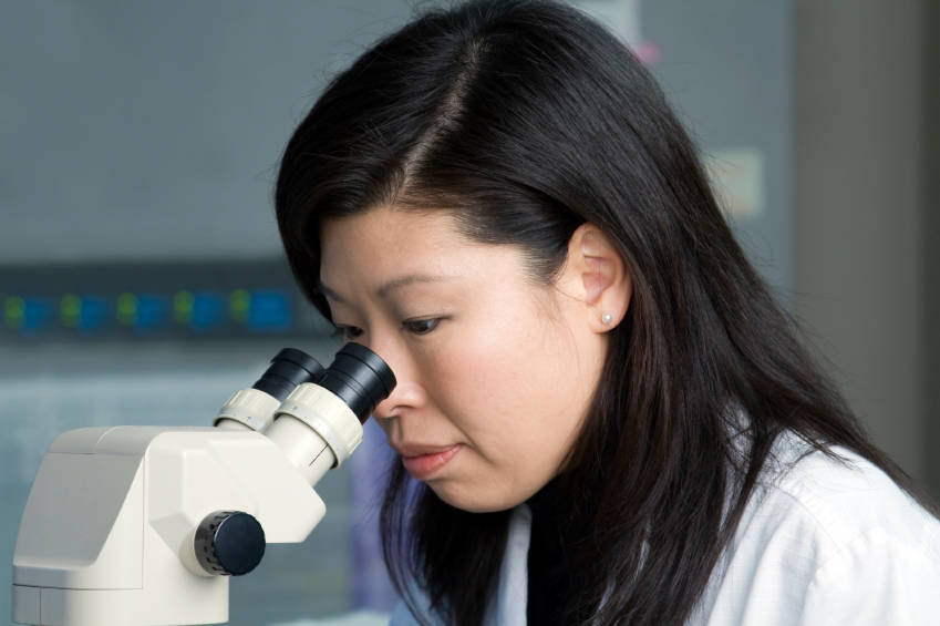 Scientist looking into microscope