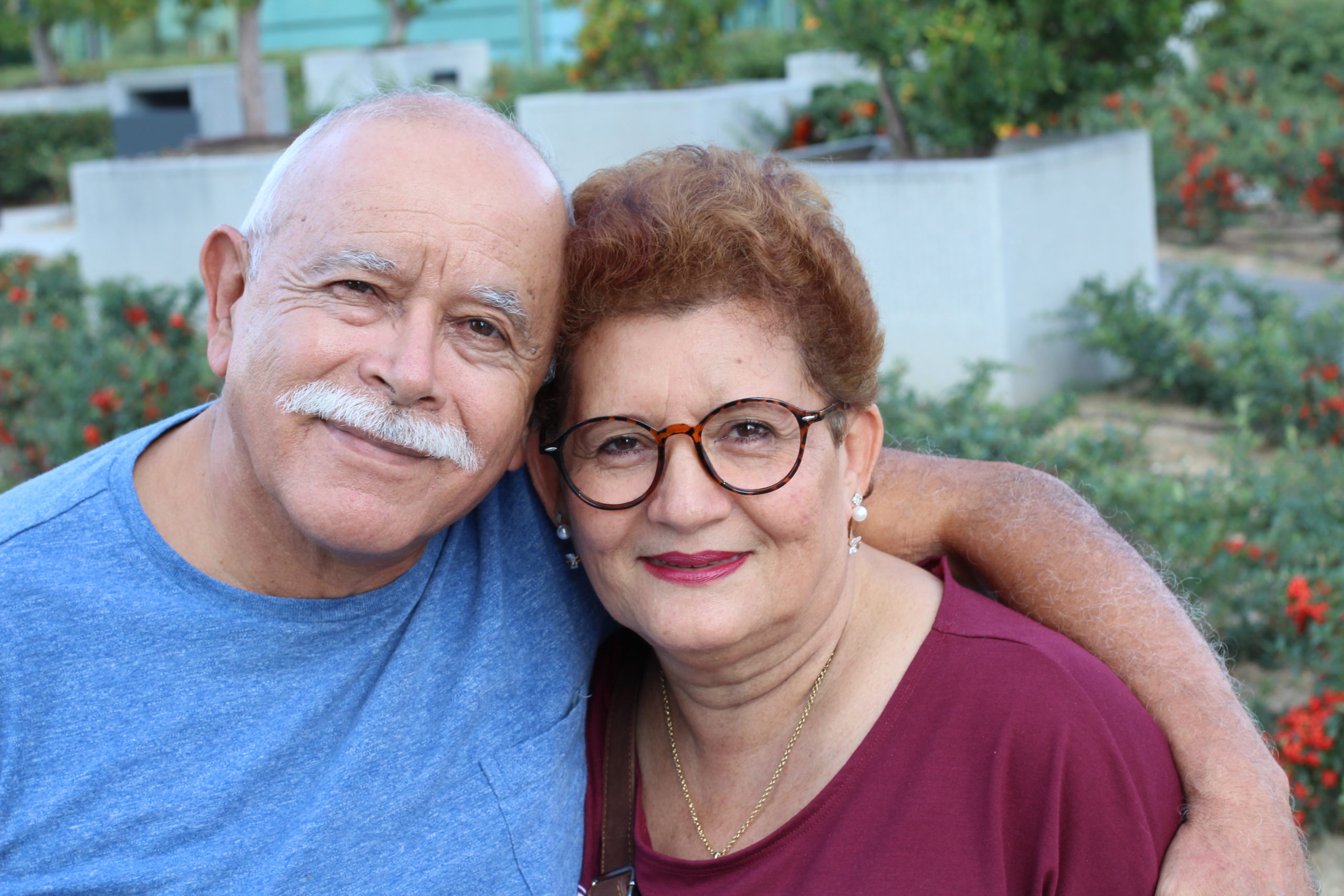 A senior couple looking into the camera smiling