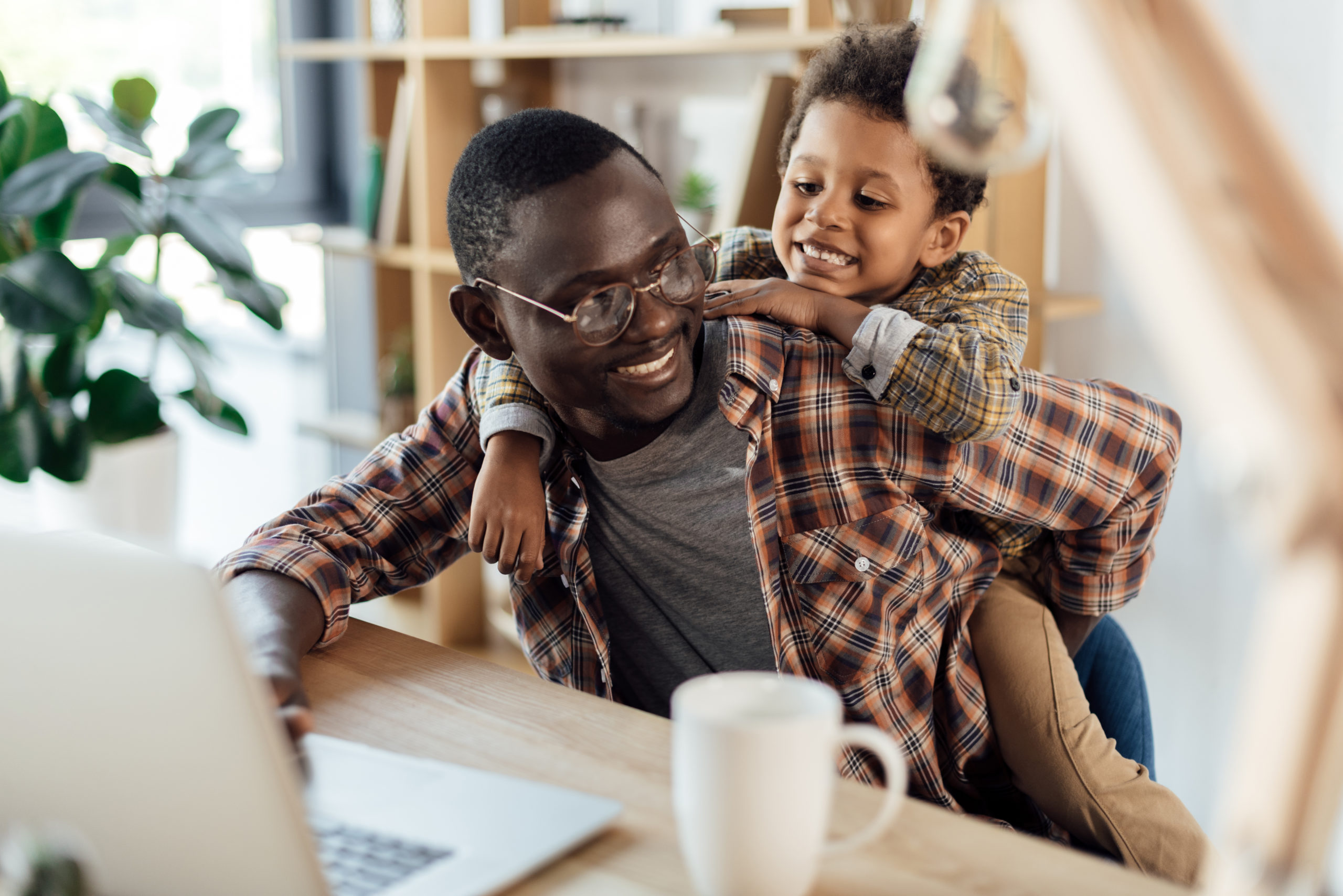 father spending time with son and working with laptop