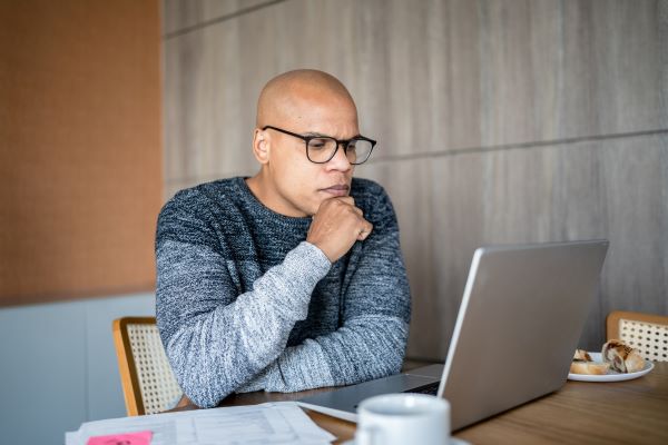 Male professional reading laptop screen