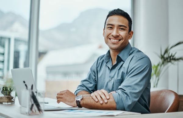 Veteran higher education professional  sitting at work desk with laptop