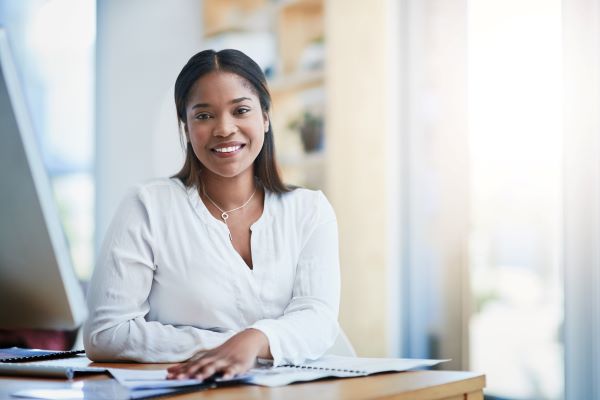 Smiling higher ed professional at work desk