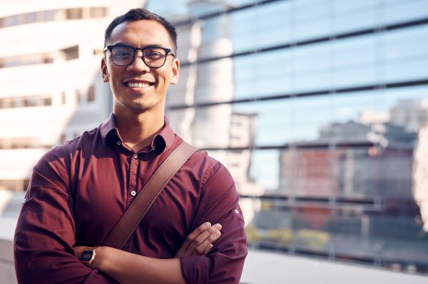 Introverted higher ed professional confidently posing in front of campus building