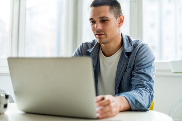 Job Seeker preparing for an interview by reviewing behavioral questions on their laptop.