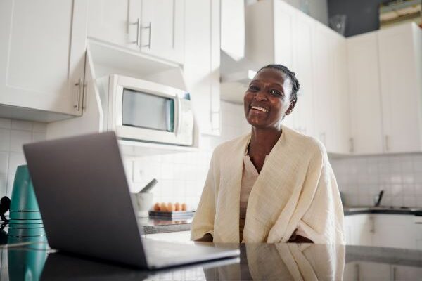 Higher ed professional taking a break from an online learning course, smiling at camera