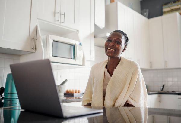 Higher ed professional taking a break from an online learning course, smiling at camera