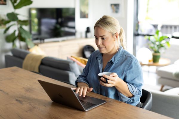 Higher ed job seeker submitting application materials on laptop