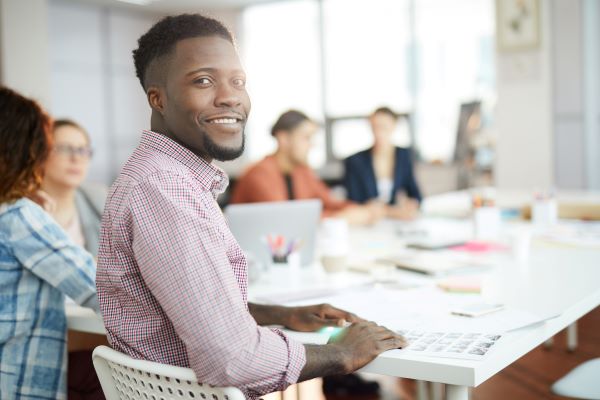 Higher ed professional onboarding for new job, participating in a team meeting.