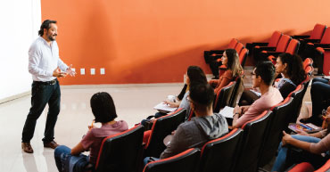 Professor teaching a lesson to students in lecture hall