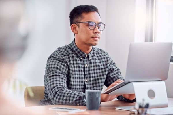 Job seeker researching potential employers on their laptop