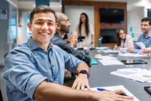 Government to Higher Ed: A former government worker smiling at camera, during an on-campus team meeting