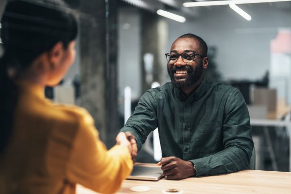 Career Growth: HIgher ed professional shaking hands with hiring manager after accepting internal job offer