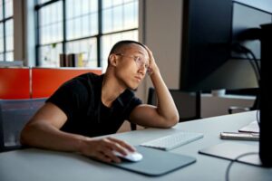 Setting Boundaries: Overwhelmed higher ed professional staring at laptop